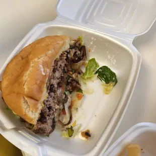 a hamburger in a styrofoam container