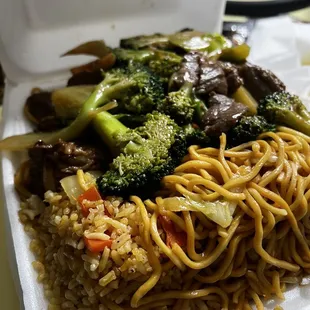 a take out box of noodles and beef
