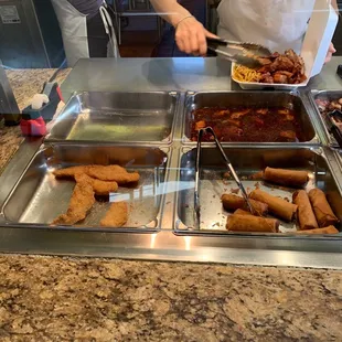 a person preparing food in a buffet