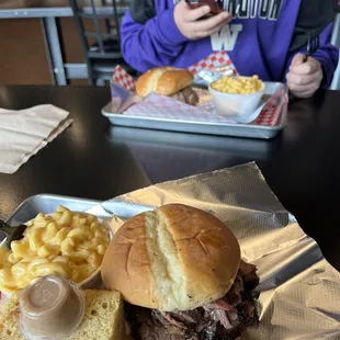 Brisket sandwich in front, pulled pork in back. Mac and cheese. Cornbread with cinnamon butter.