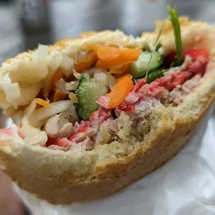 a hand holding a sandwich