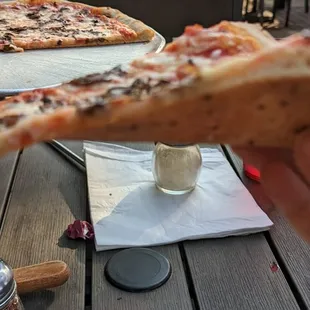 a hand holding a slice of pizza