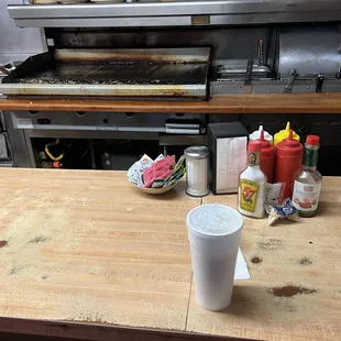 a table with a cup of coffee and condiments