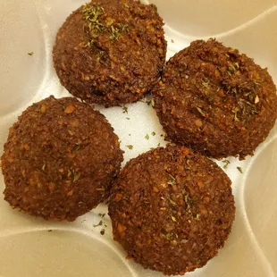 a close up of four cookies in a styrofoam container