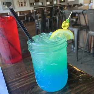 a blue drink with a slice of lemon