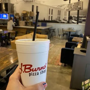  hand holding a paper cup with a straw