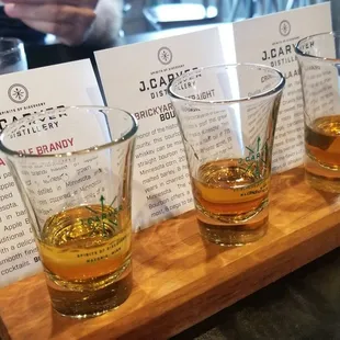  four glasses of whiskey on a wooden tray