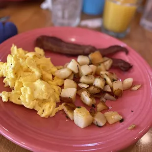 a pink plate of breakfast food