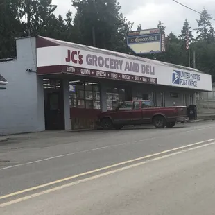 a red truck parked in front of the store