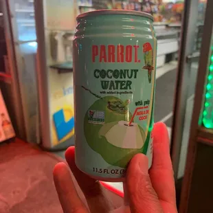  a person holding a can of coconut water