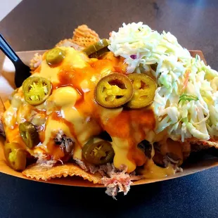 Pulled Pork Nachos: J-Mack chips, house slaw, house baked beans, nacho cheese, jalapenos and bbq sauce.