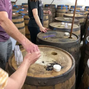 a man and a woman working on barrels
