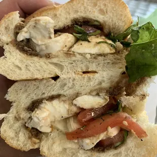 Caprese with salt and pepper on a fresh seeded braided roll.