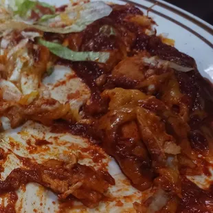 Chicken Enchilladas....folded tortillas lot of sauce and chicken on top of the enchilada