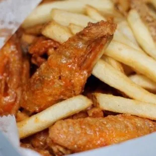 Medium sauced wings and French Fries in their signature white to go box.