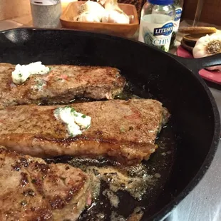 steaks cooking in a skillet
