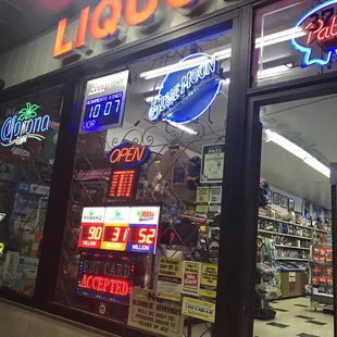 a liquor store with neon signs