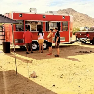 a group of people standing in front of a food truck