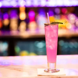 a pink cocktail on a bar