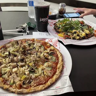 wo plates of pizza and a salad