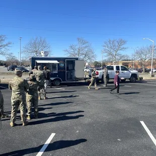 a group of soldiers standing in a parking lot