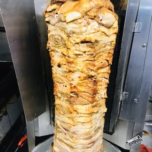 a large meat skewer being cooked in a commercial kitchen