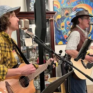 two men playing guitar and singing