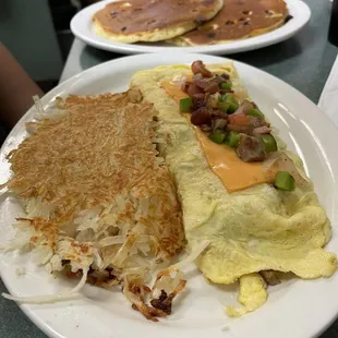 Omelette w/ hash-browns and 2 chocolate chip pancakes.
