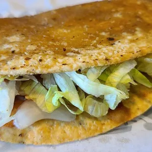 a taco with lettuce and cheese