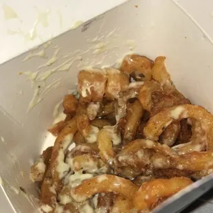 Half empty loaded "parm" fries with random black marks inside box