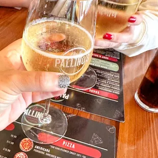 two people holding glasses of beer