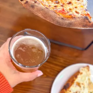a slice of pizza and a glass of beer