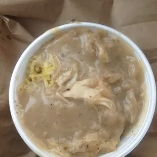 A delicious bowl of yellow rice with chicken and gravy.