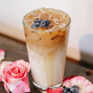 a glass of iced coffee with blueberries