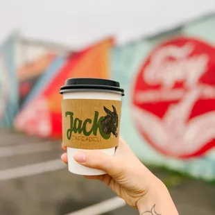 a hand holding a coffee cup