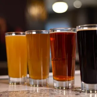 a row of beer glasses on a counter