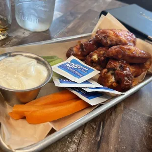 a tray of chicken wings and carrots