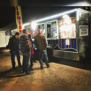 a group of people standing in front of a food truck