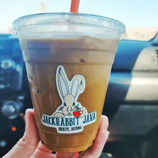 a hand holding a cup of jackrabbit java