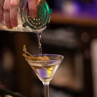 a bartender pouring a martini