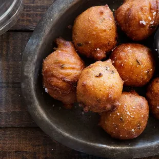 a bowl of fried doughnuts with dipping sauce