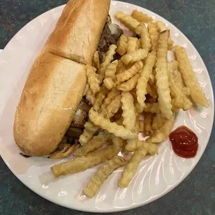 Philly cheesesteak served with fries