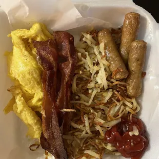 Two eggs, bacon and hash brown with a side of sausage.