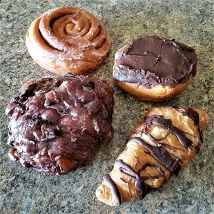apple fritter, cinnamon roll, raspberry filled chocolate bismark, and a cream filled flaky pastry