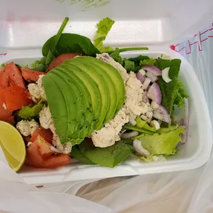 a salad in a styrofoam container