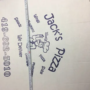 a hand holding a pizza box