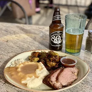a plate of meat, mashed potatoes, and gravy