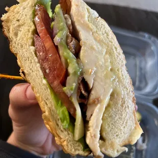 a hand holding a sandwich