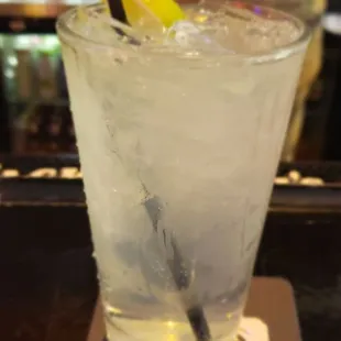 a glass of water with ice and a lemon wedge