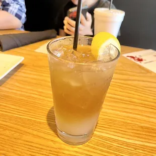 a glass of iced tea with a lemon wedge